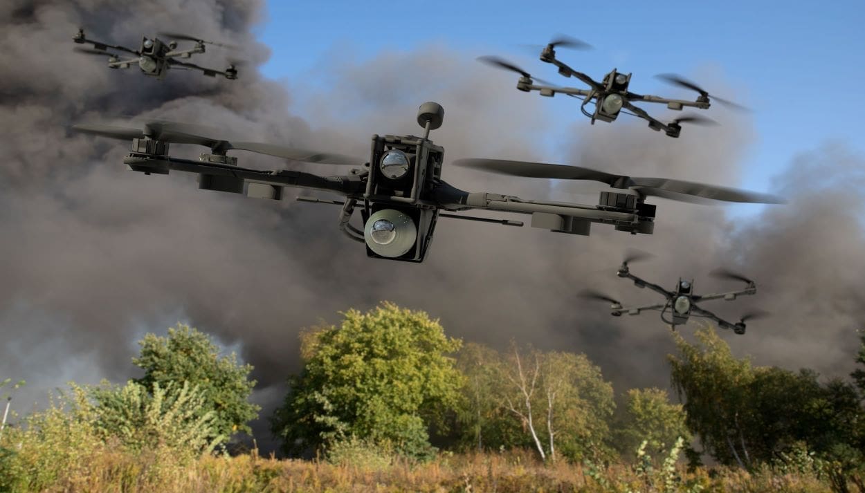Several drones are flying over a landscape with trees, and there is thick black smoke in the background.